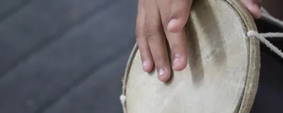 Fingers on a person’s right hand tap on a drum, symbolizing how people’s brains synchronize their movements to musical rhythm. Fingers on a person’s right hand tap on a drum, symbolizing how people’s brains synchronize their movements to musical rhythm.
