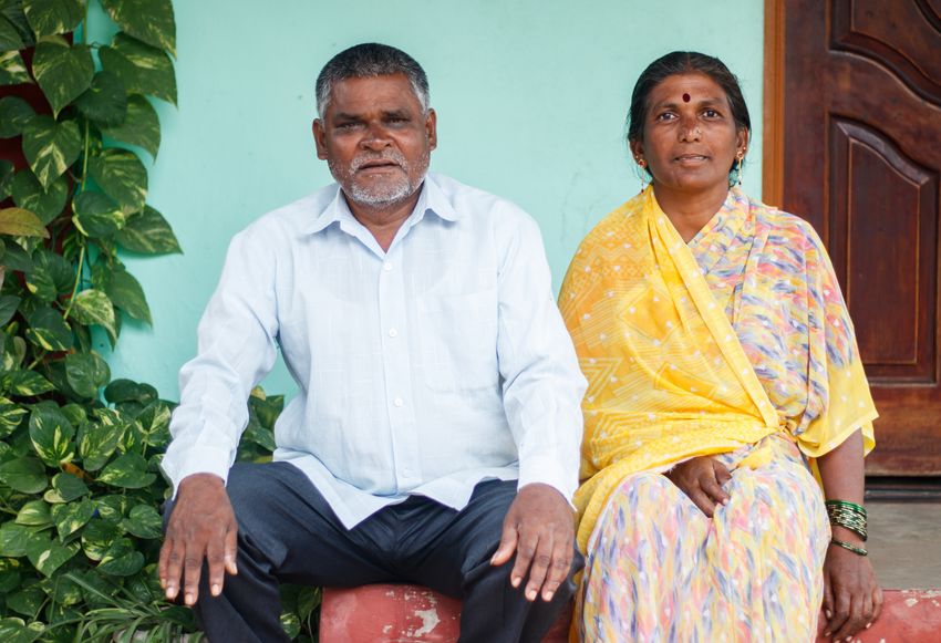Farmworkers Rajendra and Sunita Kamble sit on a ledge outside of a house. Farmworkers Rajendra and Sunita Kamble sit on a ledge outside of a house.