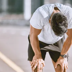 Tired man resting after fitness run, representative of exercise-induced anaphylaxis.