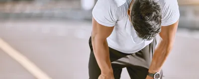 Tired man resting after fitness run, representative of exercise-induced anaphylaxis.