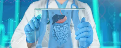 A doctor in a white coat, blue gloves, and surgical mask holds a clear screen showing a gastrointestinal tract and some medical data. A doctor in a white coat, blue gloves, and surgical mask holds a clear screen showing a gastrointestinal tract and some medical data.