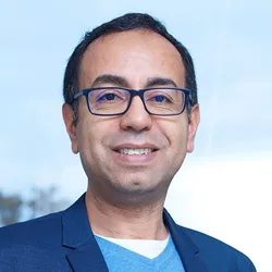 Photograph of Brahim Selmaoui. He has short dark hair and rectangle-framed glasses. 