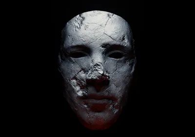 A spooky stone mask sits against a black background. A spooky stone mask sits against a black background.