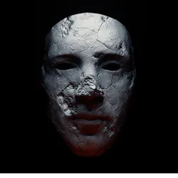 A spooky stone mask sits against a black background. A spooky stone mask sits against a black background.