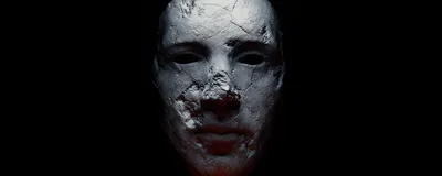 A spooky stone mask sits against a black background. A spooky stone mask sits against a black background.
