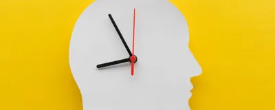 Depiction of circadian rhythm with clock hands on top of a white cutout of a human head on a yellow background. Depiction of circadian rhythm with clock hands on top of a white cutout of a human head on a yellow background.