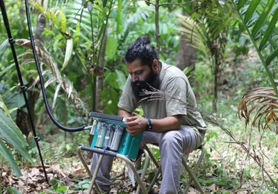 Rakesh Tiwari, a postdoctoral fellow and plant physiologist at Uppsala University, collects photorespiration measurements from plants in the Western Ghats Forest.