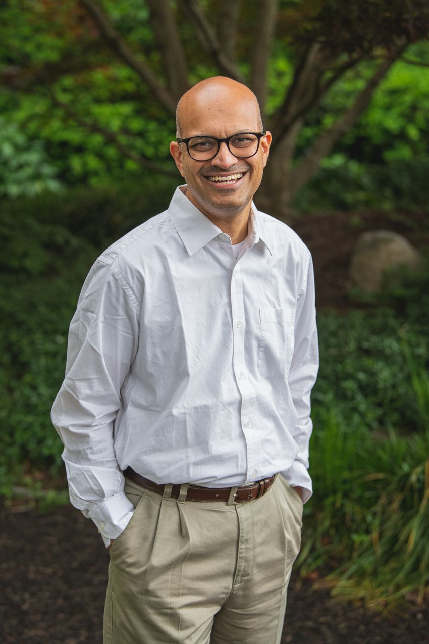 Santhosh Girirajan, a human geneticist at Pennsylvania State University, stands for a photograph in front of a blurred background of a tree and grassy space. He is wearing a long-sleeved white shirt, tan pants, and has black-framed glasses. He is smiling at the camera. Santhosh Girirajan, a human geneticist at Pennsylvania State University, stands for a photograph in front of a blurred background of a tree and grassy space. He is wearing a long-sleeved white shirt, tan pants, and has black-framed glasses. He is smiling at the camera.