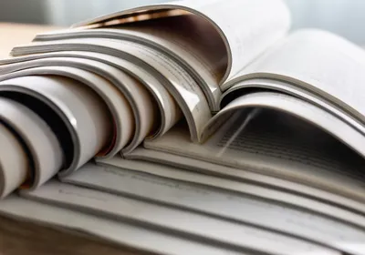 Scientific journals sit open on top of each other in a stack. Scientific journals sit open on top of each other in a stack.