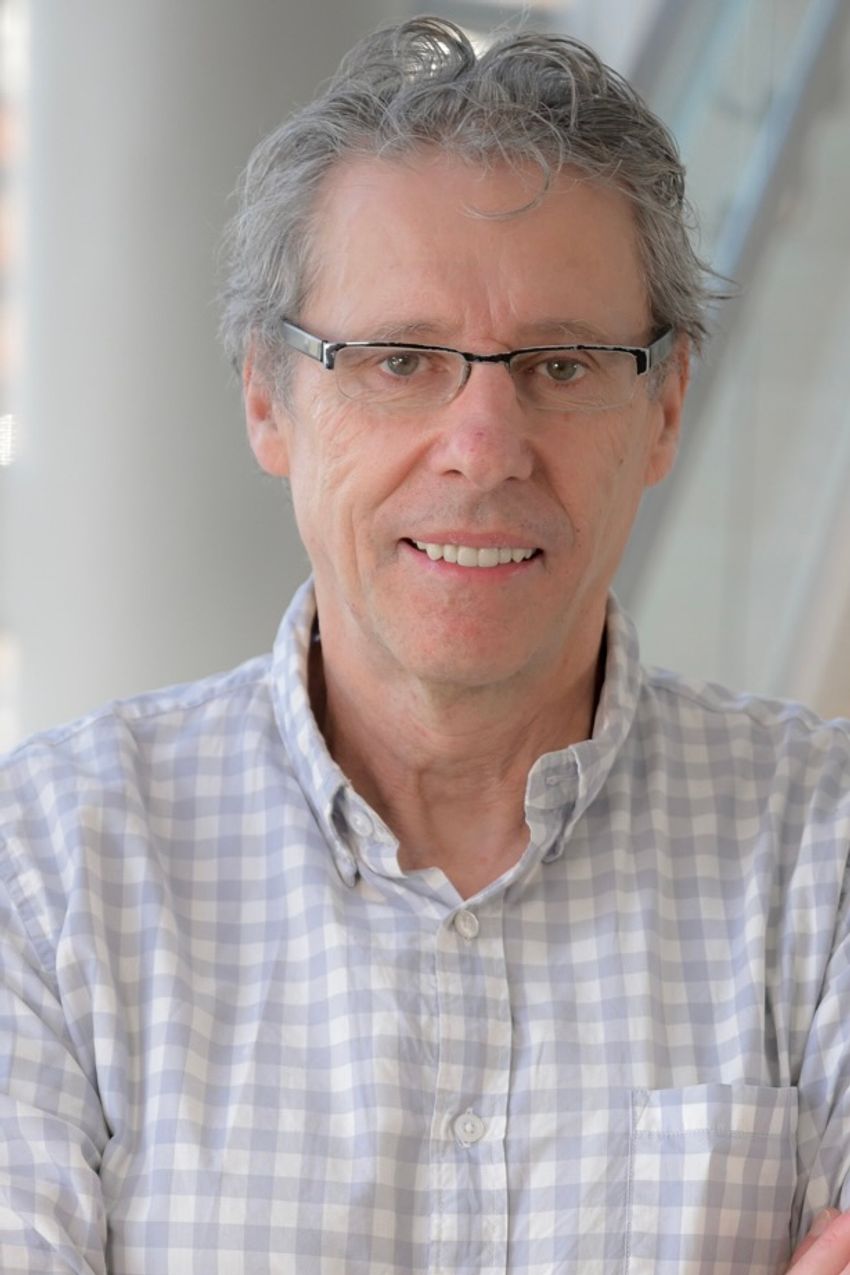 Photo of Giles Martin wearing glasses and a white and lavender checkered shirt.