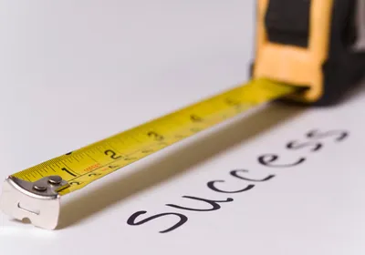Measuring tape measuring text success, signifying metrics like h-index that quantify academic success.