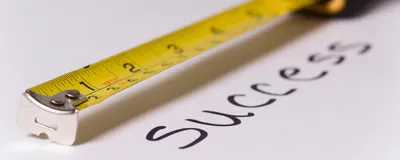 Measuring tape measuring text success, signifying metrics like h-index that quantify academic success. 
