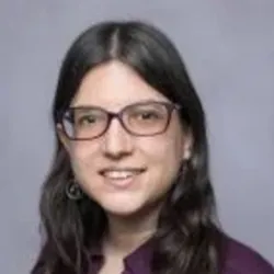 Christina Nicholas smiles and wears glasses in a headshot image.