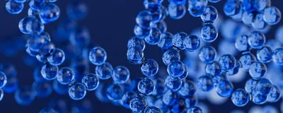 An illustration of small blue spheres representing electric field-controlled nanoparticles clustered together.