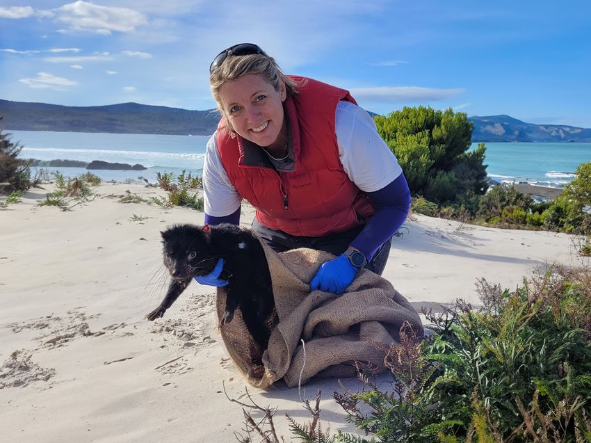 Image of Carolyn Hogg posing with a Tasmanian devil in her hand.