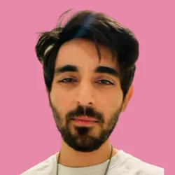 Saif Khan wears a white shirt against a pink background in a headshot.