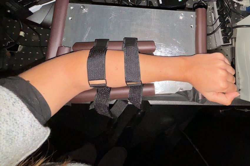 A person’s arm strapped to a shoebox-sized device that used Raman spectroscopy to track blood glucose levels noninvasively.