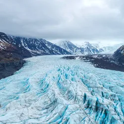 An aerial view of a glacier, which houses millions of microbes within its icy interior. 