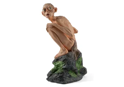 Gollum, the extremely territorial character from The Lord of the Rings, famous for his line, “My precious,” sits on a rock, looking up.  