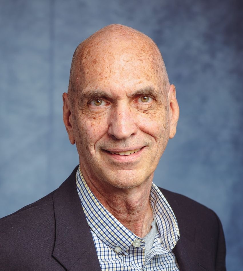 Holden Maecker, a cellular immunologist at Stanford University, wears a blue suit and a checkered shirt.