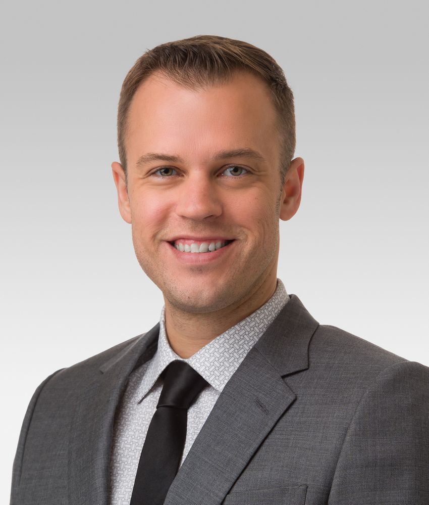 David Gate, a neuroimmunologist at Northwestern University, wears a grey suit and black tie in a headshot taken in front of a white background.