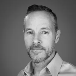 Derek Jantz wears a collared shirt in this black and white headshot photo.