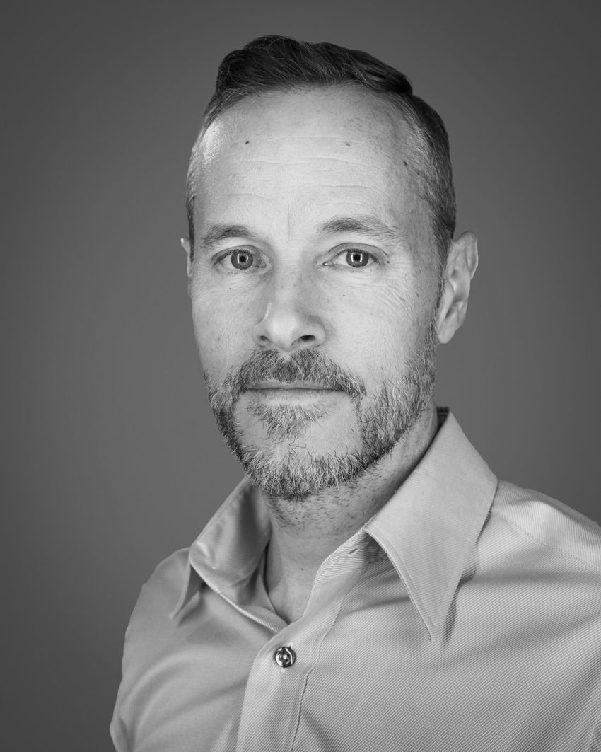 Derek Jantz wears a collared shirt in this black and white headshot photo.