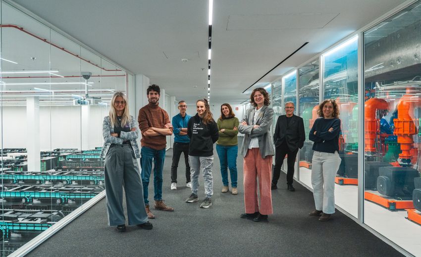 Eight people stand in a corridor in a supercomputer facility. The researchers carried out RNA sequencing of diverse samples to uncover the extent of Eurocentric ancestry bias in transcriptomics.