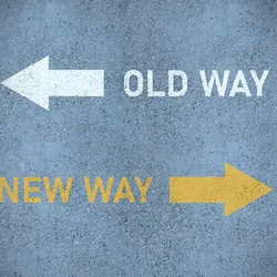 Photograph showing the words “Old Way” in white with a white arrow pointing to the left and, below that, the words “New Way” in yellow with a yellow arrow pointing to the right on a background that resembles pavement. This represents changing academic processes for the future. 