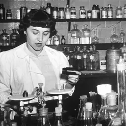 Cancer researchers work in an NIH laboratory in a black and white photo.