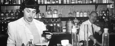 Two cancer researchers work in an NIH laboratory in a black and white photo.