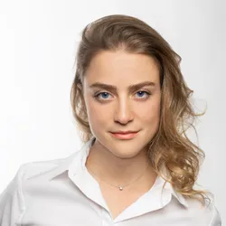 Elisabetta Burchi wears a white collard shirt and stands against a white background in a headshot photo.