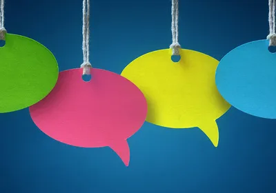 Four colorful speech bubbles hang in front of a blue background.