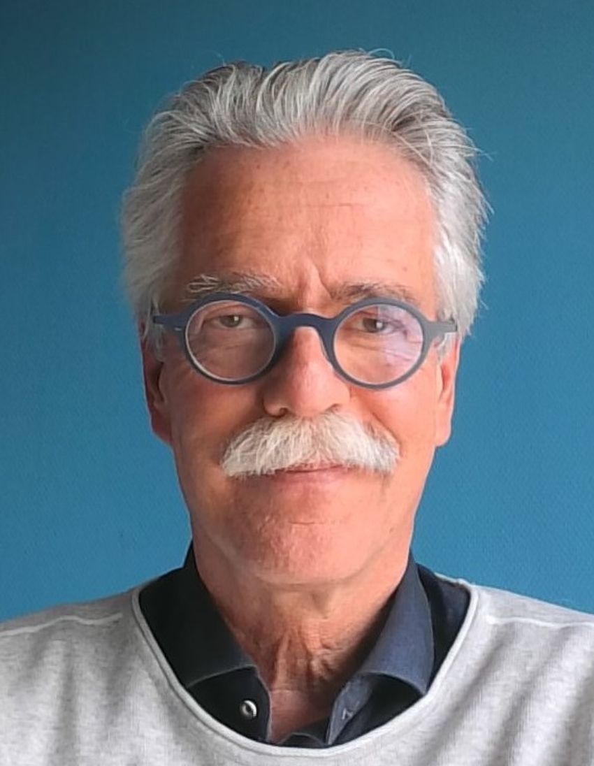 A headshot of Jelte Bos, who studies motion perception, wearing a navy-blue shirt, grey sweater, and glasses.