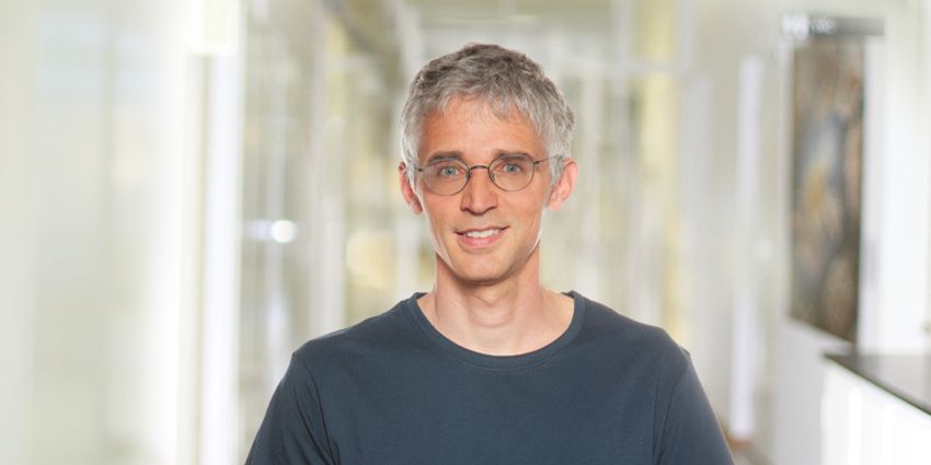 Lucas Boeck, wearing a dark-colored tee and glasses, poses in front of a light-colored, blurred background. Lucas Boeck, wearing a dark-colored tee and glasses, poses in front of a light-colored, blurred background.