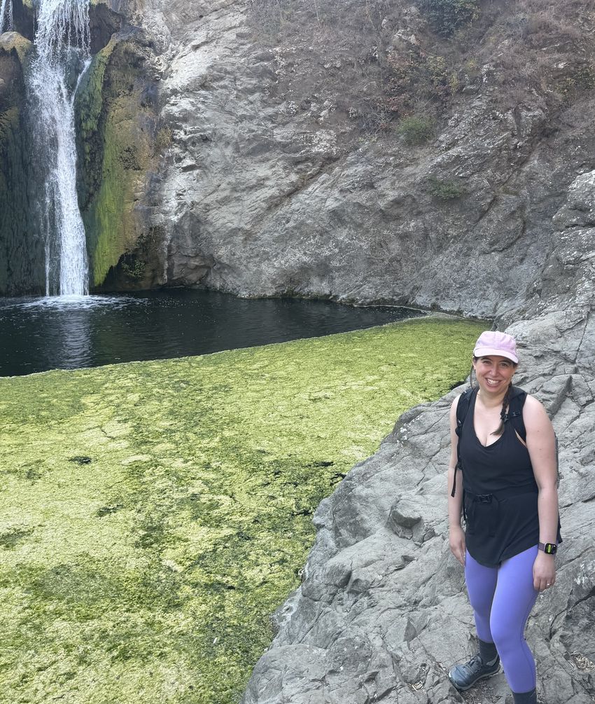 Image of Stephanie DeMarco posing in front of a waterfall.