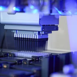 Photo of an automated liquid handling device pipetting liquid into a multi-well plate. Photo of an automated liquid handling device pipetting liquid into a multi-well plate.