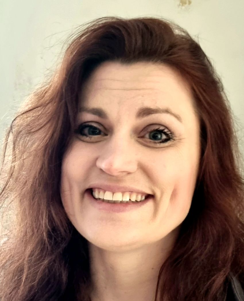 A photograph of Wendy Ross, who studies the role of serendipity in problem solving. She smiles at the camera.