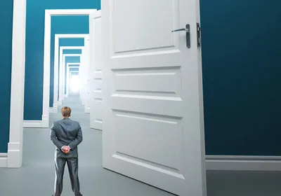 Person standing in front of long way of opened doors, indicating an environment where scientists thrive in an atmosphere that allows them to pursue serendipitous observations. 