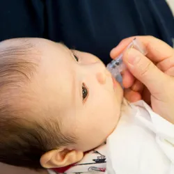 Infant receiving oral vaccination.