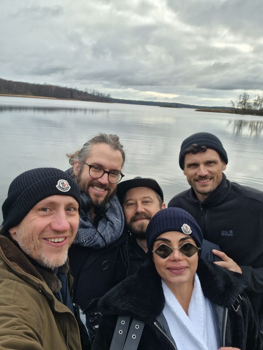 The photo shows four men and one woman, Kiana Aran, in jackets standing lakefront. Aran swam in the lake right after she got out of her five-day darkness retreat experience.