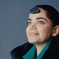 The photo shows Kiana Aran, after she just got out of her darkness retreat and opened her eyes, smiling. An EEG sensor is attached to her forehead.