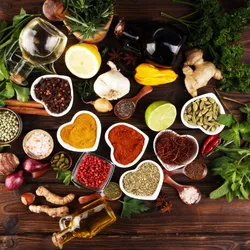 Spices on a table arranged in the shape of a heart, signifying the MASALA study which investigates South Asian population’s risk factors for cardiometabolic disease. 