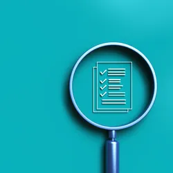 A magnifying glass over a regulatory compliance checklist icon