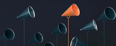 Ten dark blue megaphones and one orange megaphone stand pointing in different directions and at different heights against a dark background. The orange megaphone stands out because of its different color and it is one of the tallest megaphones.