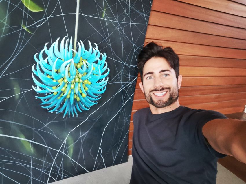 A selfie of Chris Thorogood with his large painting of a jade vine.