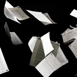 White papers representing scientific publications are shown flying up in the air against a black background.