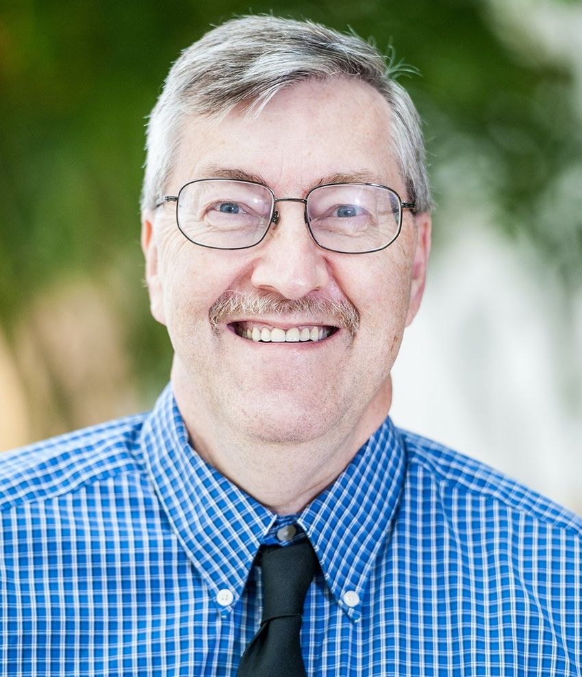 A photograph of Thomas Annesley wearing a blue shirt, navy blue tie, and glasses. A photograph of Thomas Annesley wearing a blue shirt, navy blue tie, and glasses.