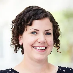 Victoria Marsh Durban smiles in a headshot while wearing a black and white polka dot shirt.