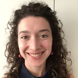 Carolyn Walsh smiles against a white wall in a headshot.